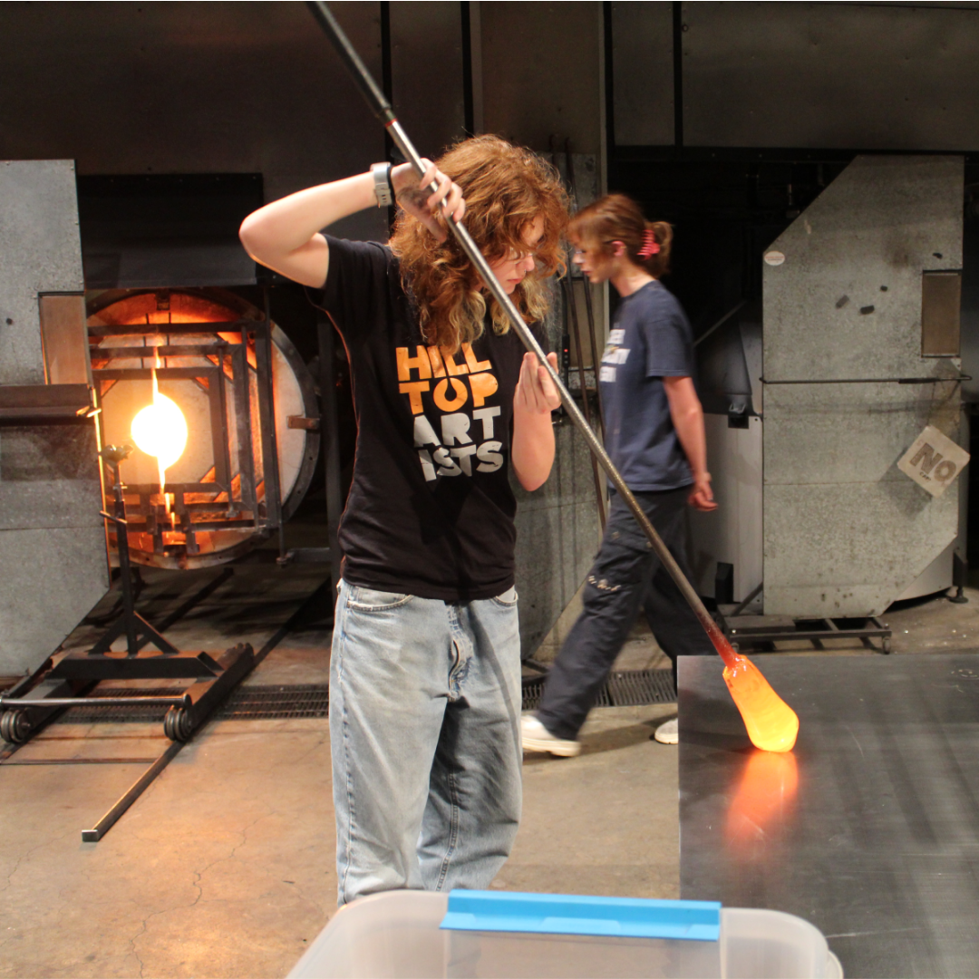 Photograph of a Hilltop Artists student during a demonstration at the Museum of Glass