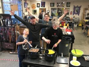 Greg Piercy and Hilltop Artists students during a production party in the hot shop