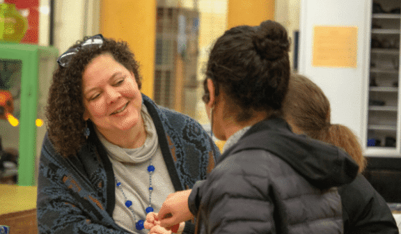 Photograph of Hilltop Artists' Executive Director Dr. Kim Keith chatting with students