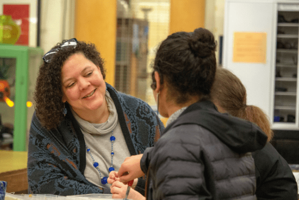 Photograph of Hilltop Artists' Executive Director Dr. Kim Keith chatting with students