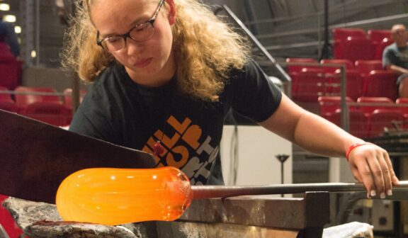 Hilltop Artist Nikki works on a glass piece during a demonstration at Museum of Glass