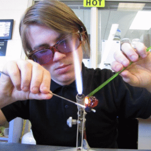 Hilltop Artist Ezekiel working on the torch in the hot shop.
