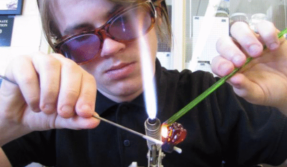 Hilltop Artist Ezekiel working on the torch in the hot shop.