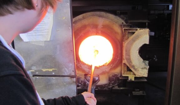 Hilltop Artist at the furnace while working on a glass piece in the hot shop.
