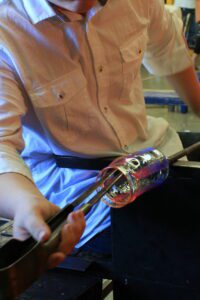 Hilltop Artists student Sam works on a glass piece on the bench.