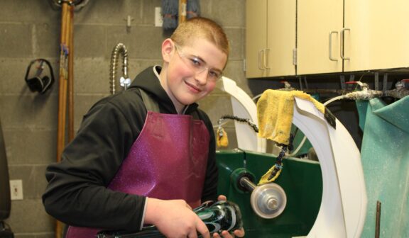 Hilltop Artist Tanner finishes a glass piece in the cold shop