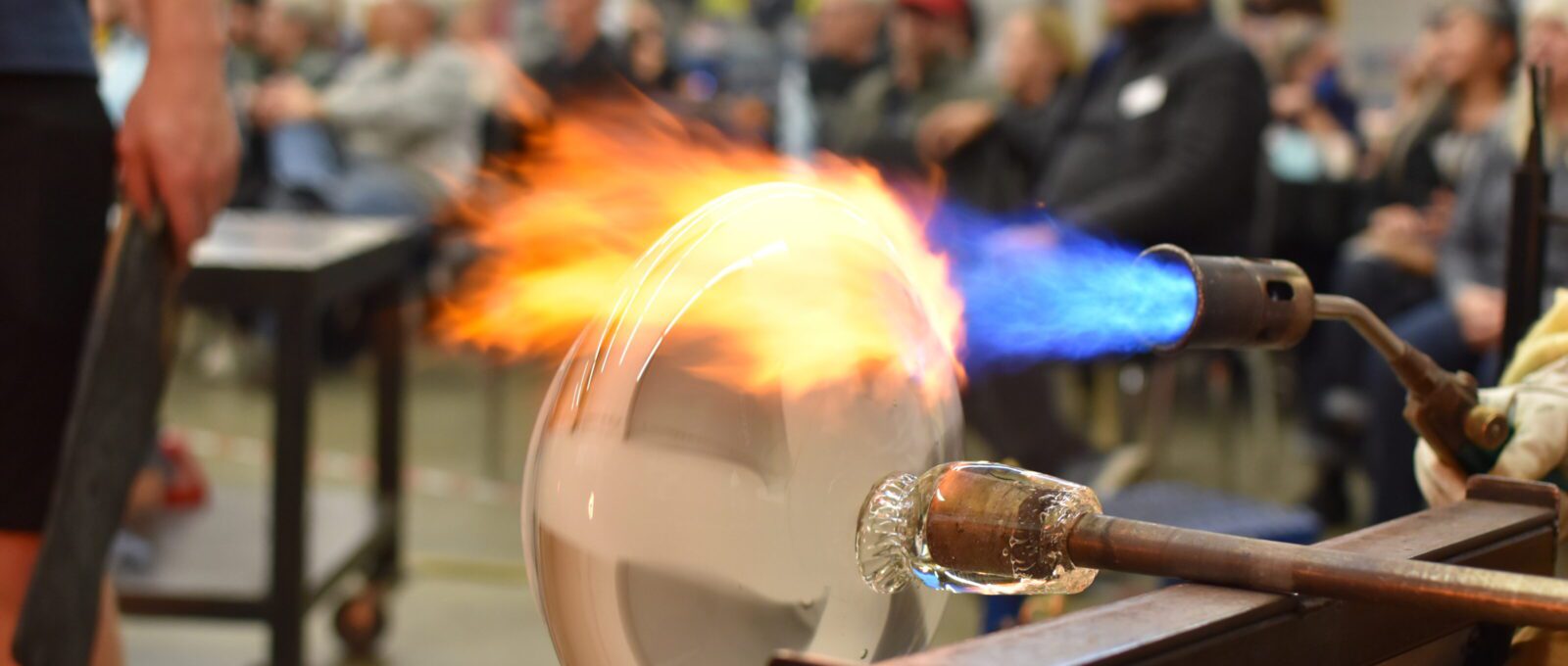 Close up image of a blown glass piece in progress being heated during at demonstration at Hilltop Heritage Middle School
