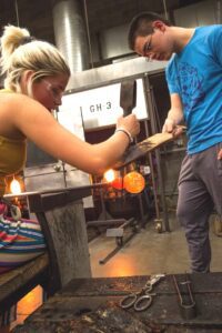 Hilltop Artists Production Students collaborate on a piece in the hot shop