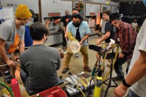 Hilltop Artists collaborate on a large, winter-themed piece in the hot shop