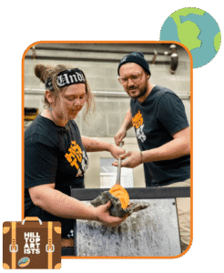 Hilltop Artists instructor, Jonathan, assists student Dasein on the glassblowing bench