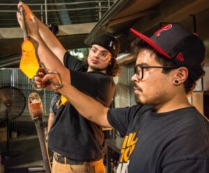 Current instructors Jacob and Trenton collaborate on a piece at the Museum of Glass when Jacob was still a student