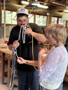 Teaching Artist Jacob demonstrates a neon technique to current student Theo at Pilchuck