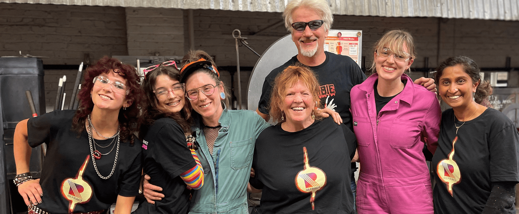 Hilltop Artists Katie and Stina with a bevy of renowned glass artists during Refract 2024