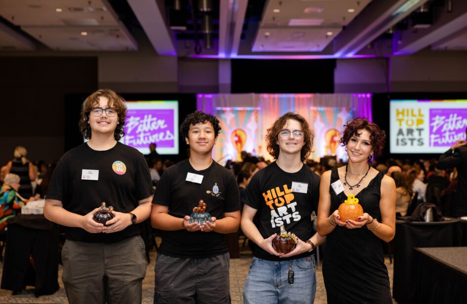 Group photograph of Hilltop Artists students holding glass pumpkins during the 2025 Better Futures Luncheon