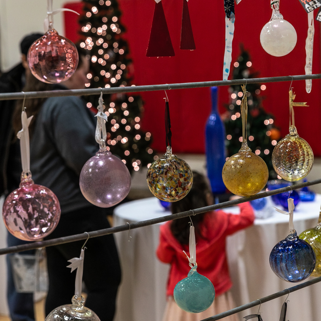 Photograph of glass ornaments in various colors hanging on a line at the Winter Glass Sale