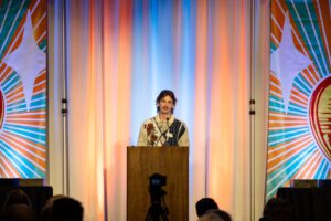 Zane introduces a student speaker at the 2025 Better Futures Luncheon