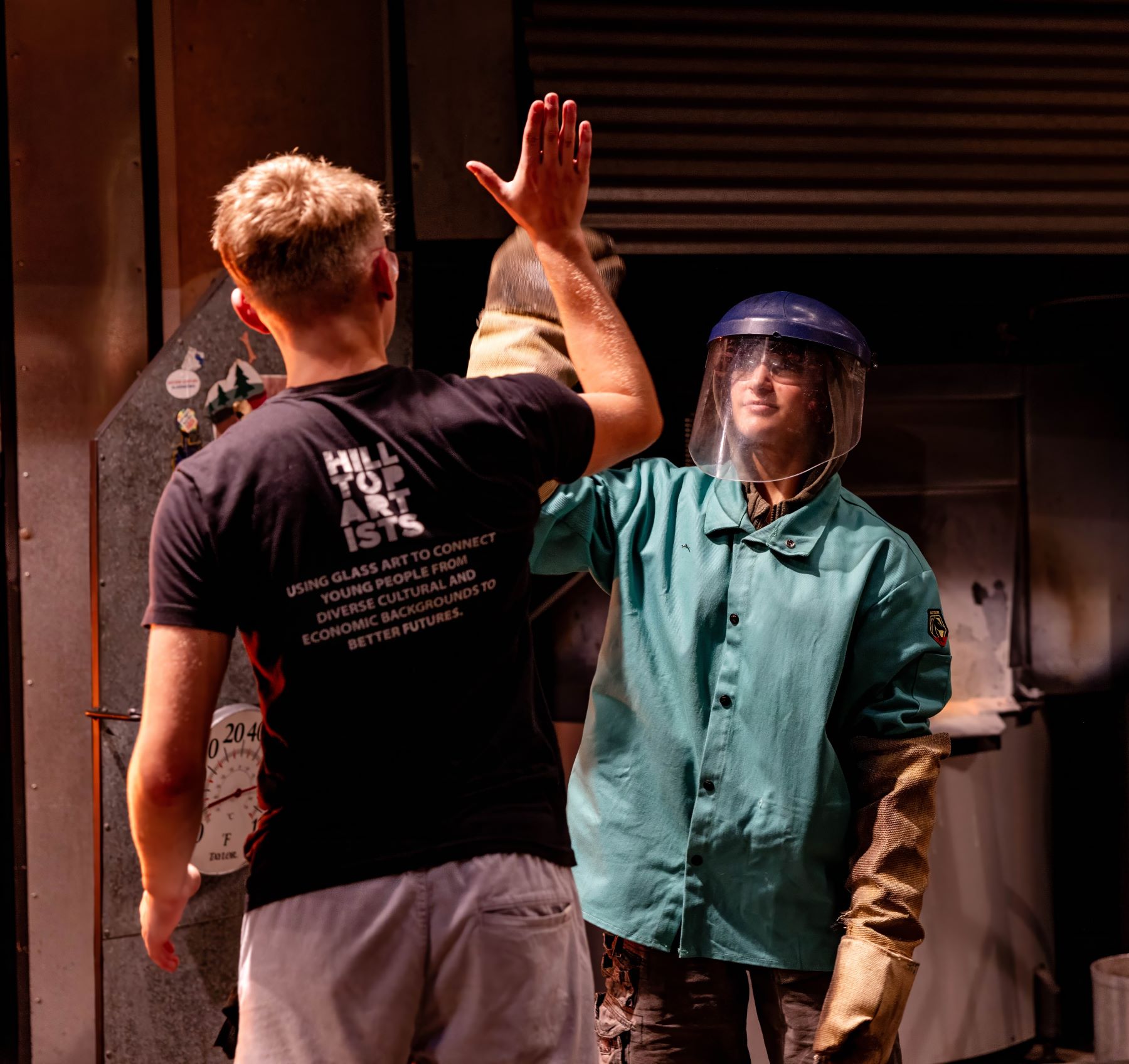Photograph of Hilltop Artists students during a demonstration at the Museum of Glass