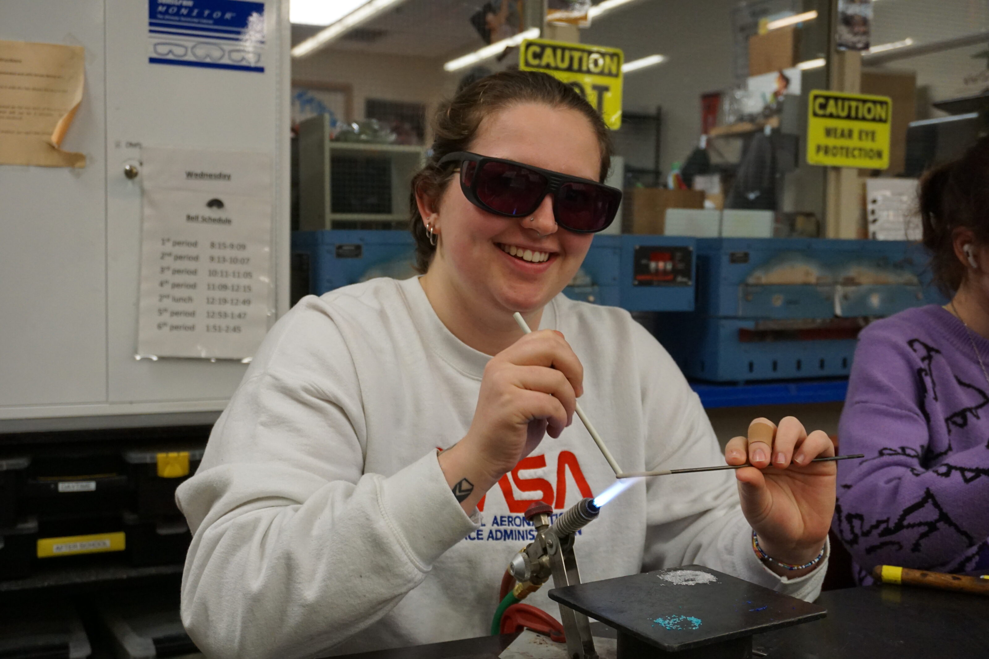 Photo of Hilltop Artists instructor Carleigh working on a bead torch during an event in the hot shop.